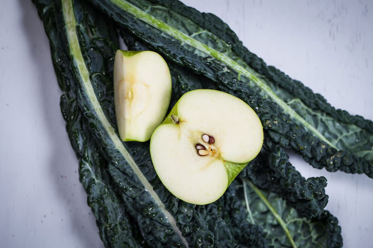 Raw Dinosaur kale with a sliced green apple