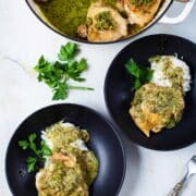 Pan-seared chicken thighs on top of cooked rice and topped with a pesto sauce.