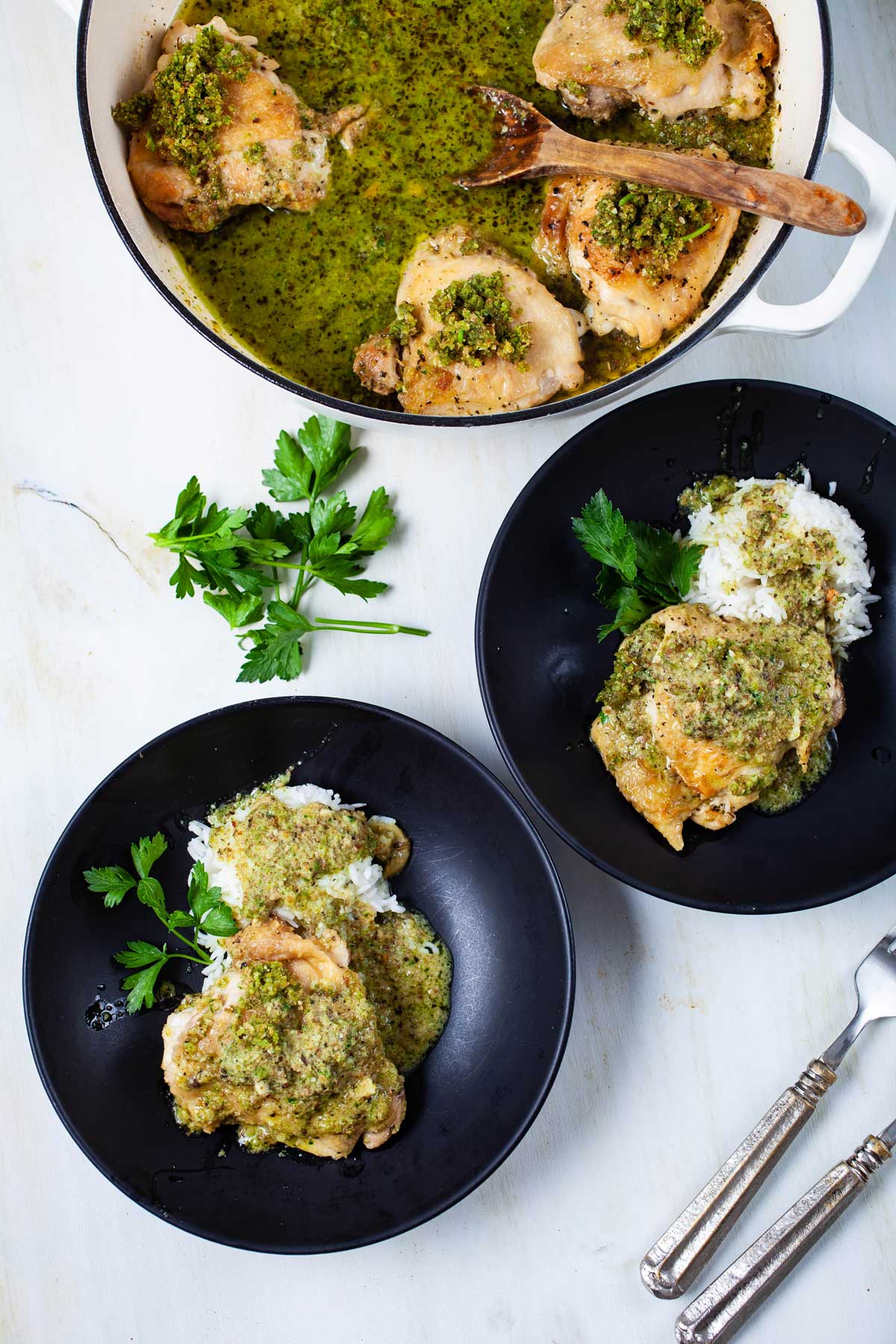 Pan-seared chicken thighs on top of cooked rice and topped with a pesto sauce.