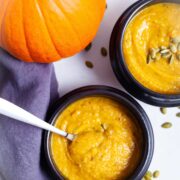 Creamy cauliflower pumpkin soup served in bowls.