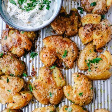 Smashed potatoes baked until crispy on a large baking sheet.