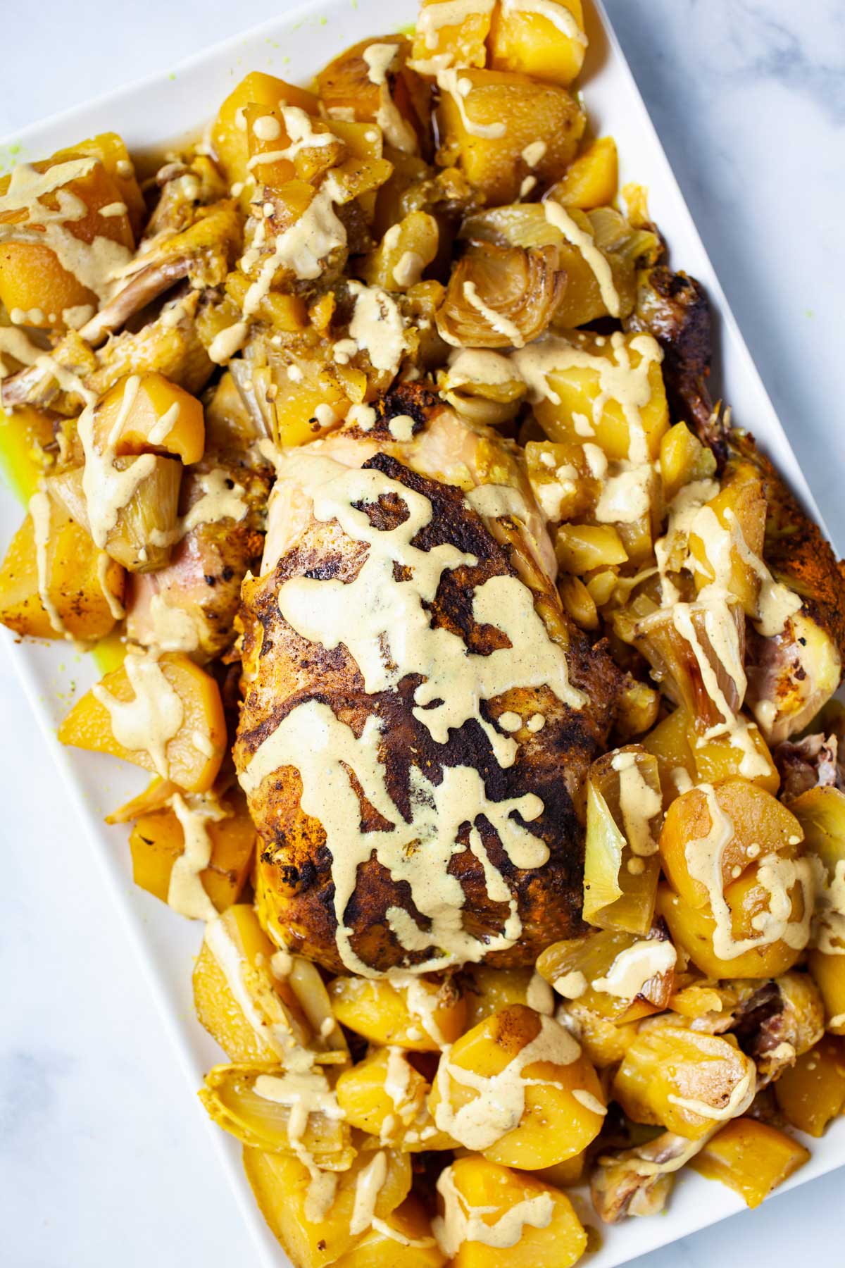 A beautiful dish with a whole chicken and potatoes topped with a healthy gravy.
