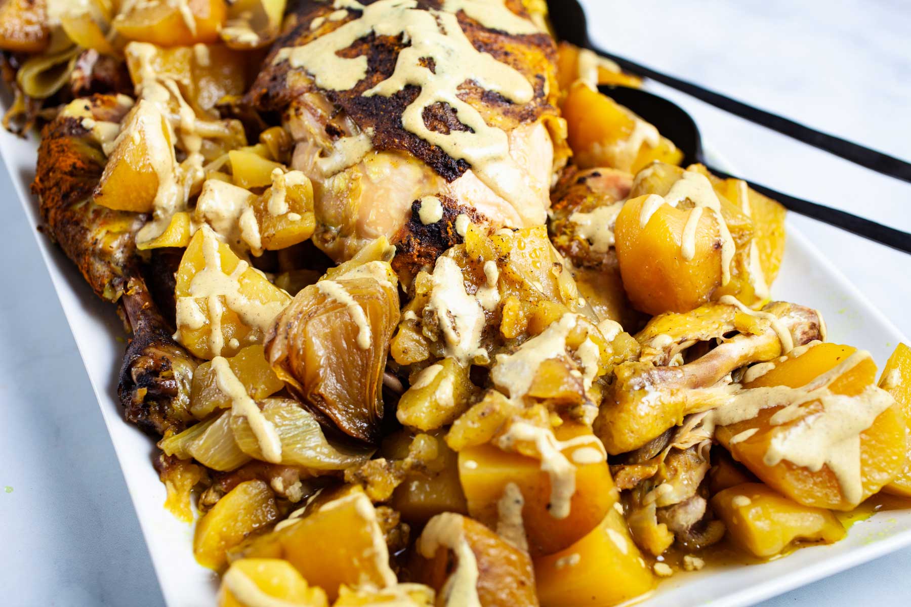 A beautiful dish with a whole chicken and potatoes topped with a healthy gravy.