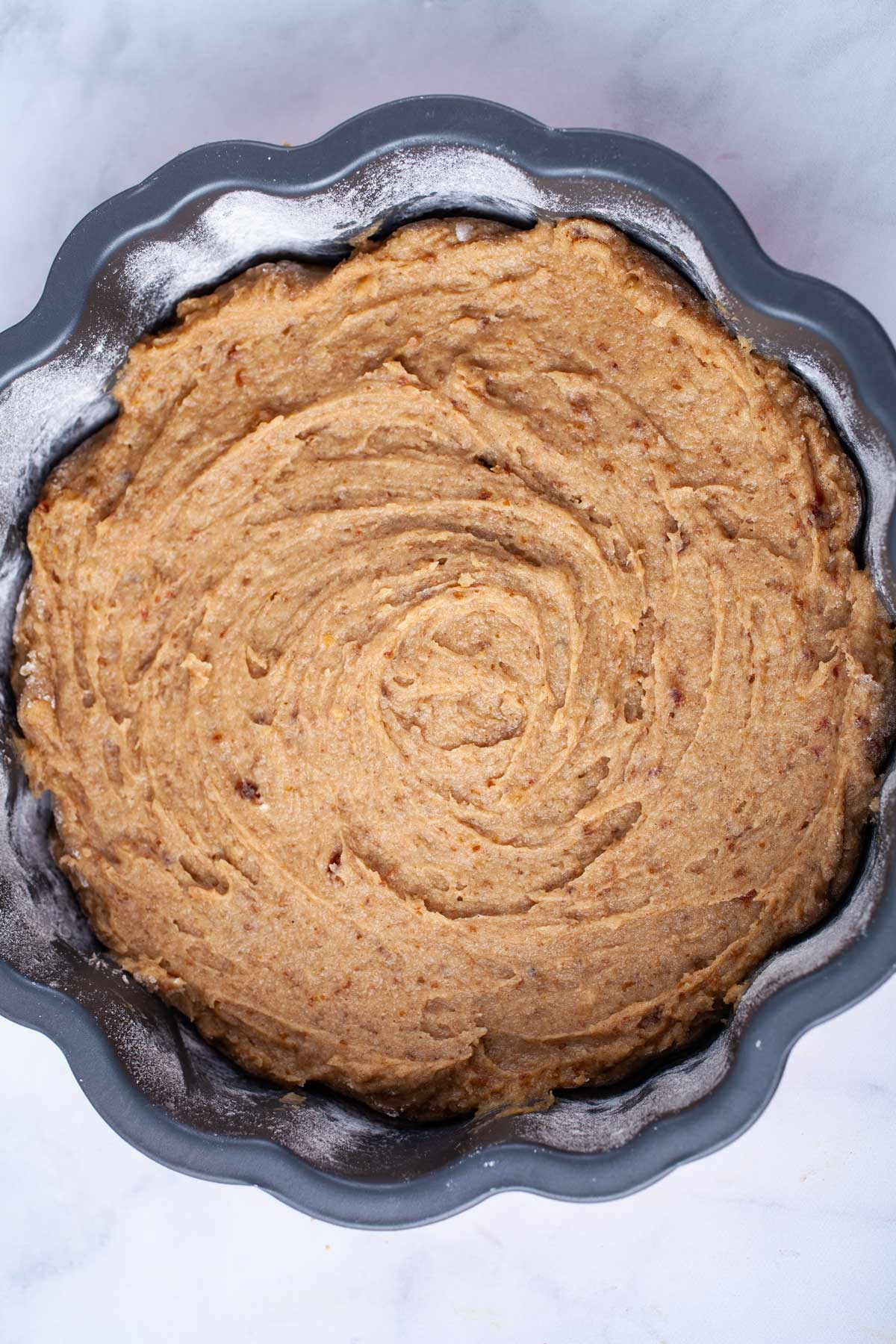 Cake batter in a prepared baking pan.