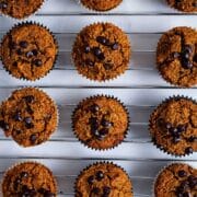 Chocolate chip date pumpkin muffins on a cooling rack.