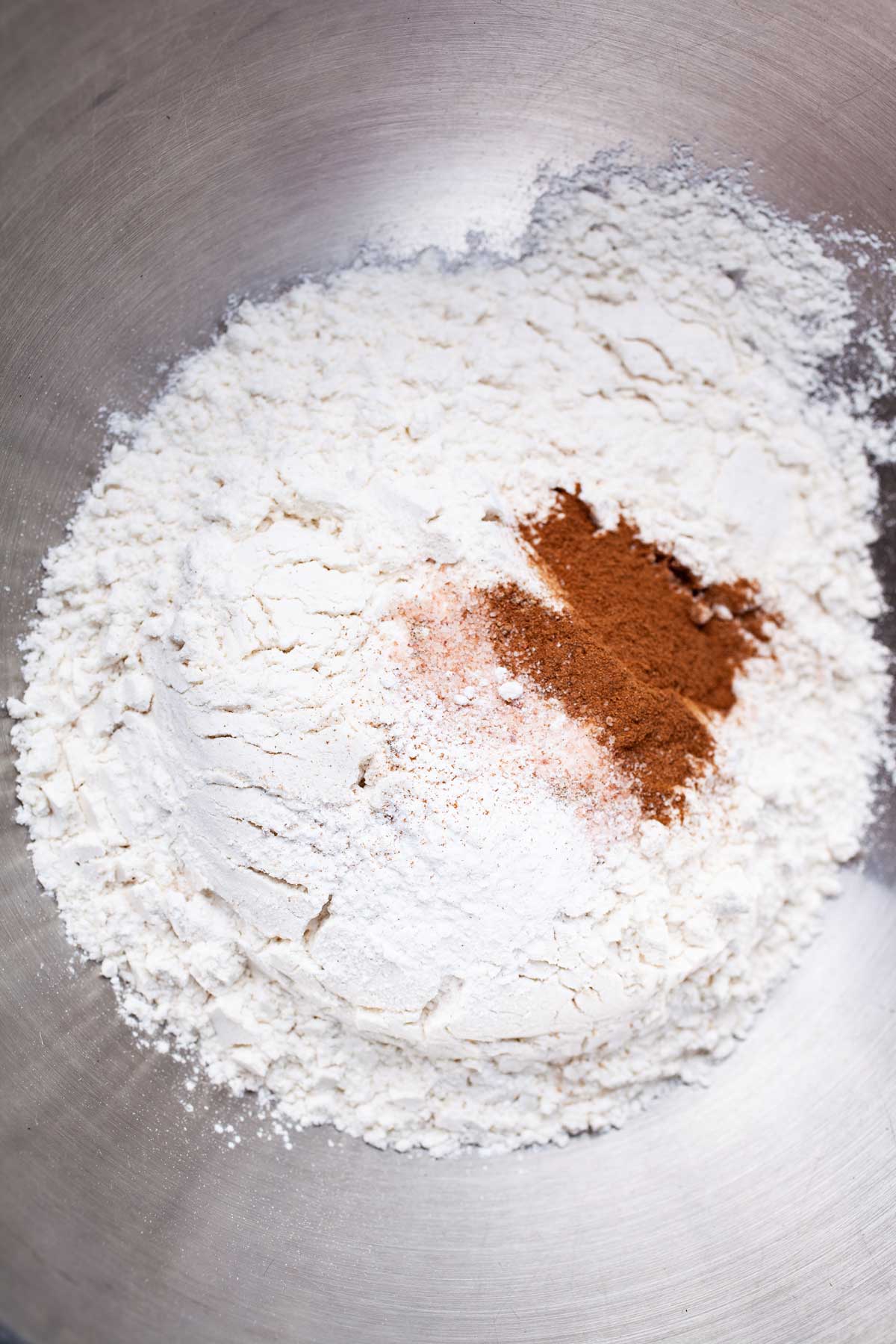 Flour and spices in a stainless steel bowl.