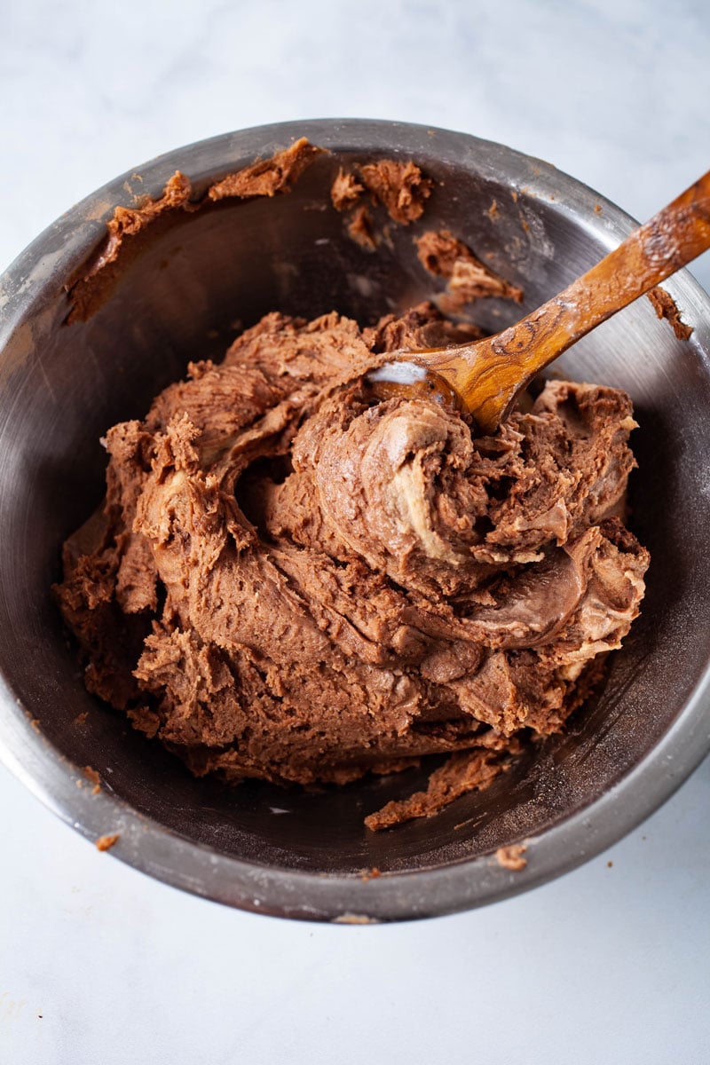 A wooden spoon swirled in chocolate cookie dough.