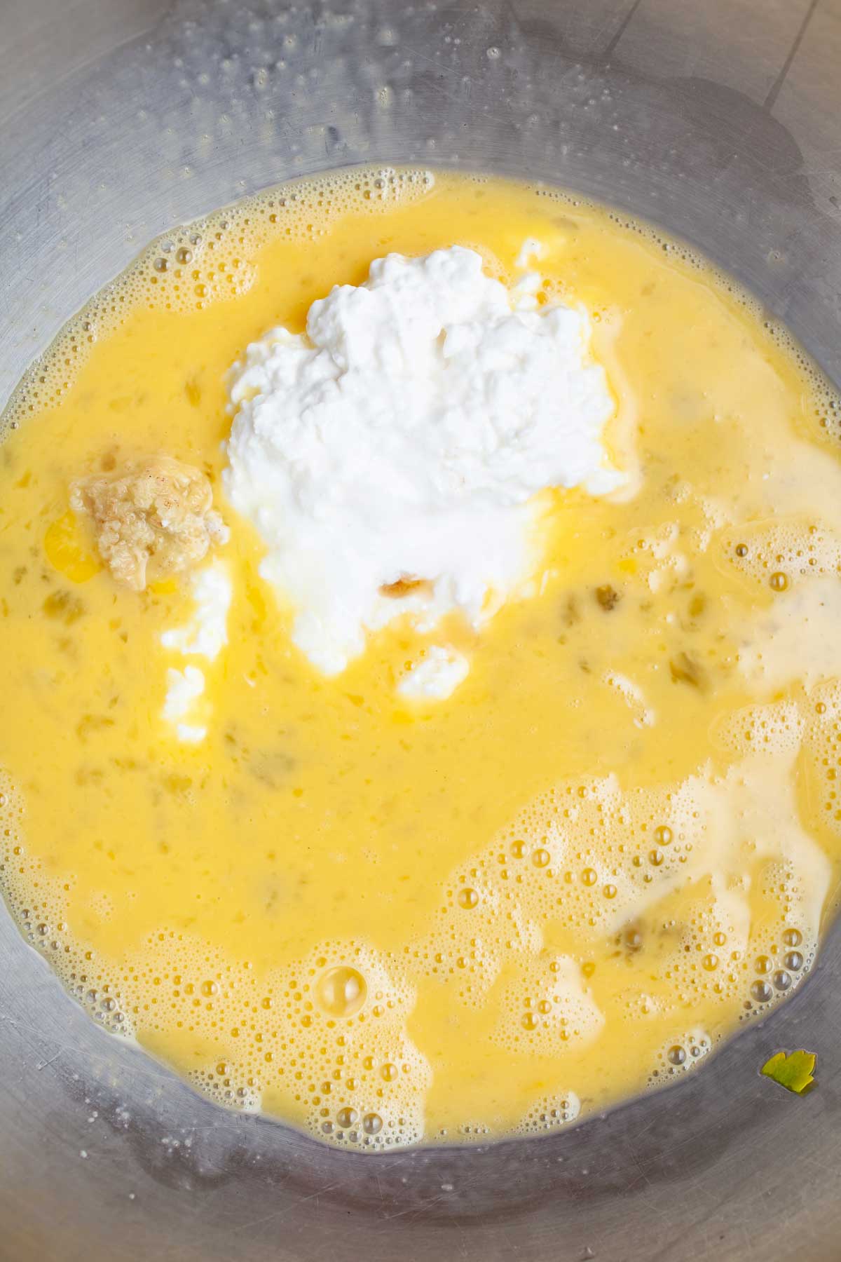 Beaten eggs with cottage cheese and grated ginger in a large bowl.