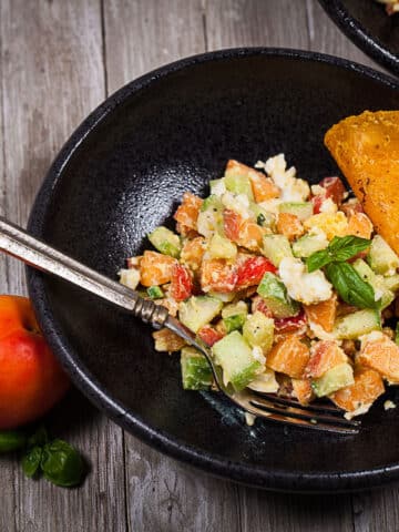 A bowl filled with a healthy apricots egg salad with a taco on the side and a fork.