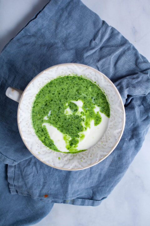 A small bowl filled with yogurt and a herbal green mixture.