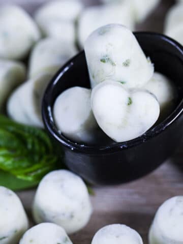 A close up of heart shaped white ice cubes in a bowl.