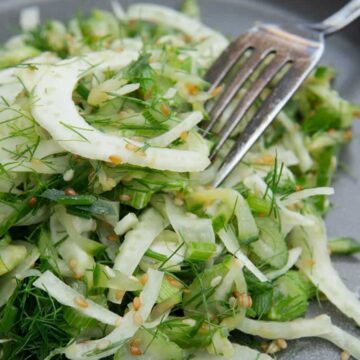 Finely sliced fennel seasoned on a plate.