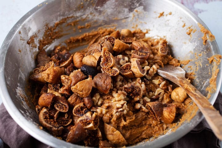 Dried figs being stirred into a cake batter.