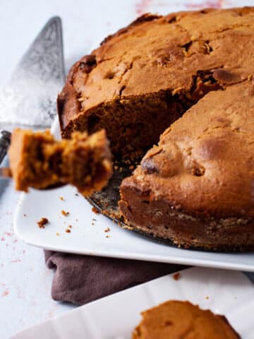 A slice taken out of a baked fig cake.