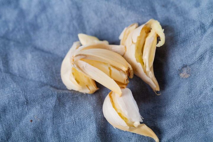 Shredded garlic cloves resting on a blue kitchen towel.