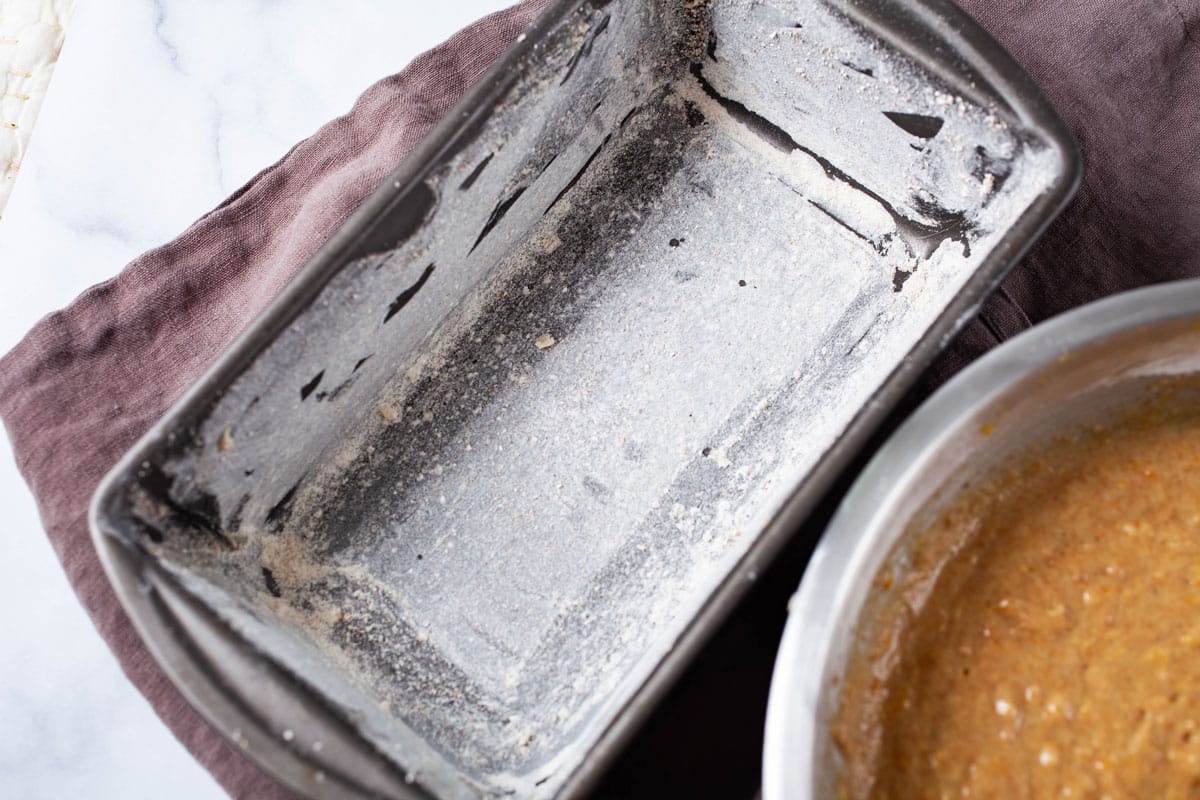 A greased and flour dusted prepared loaf tin pan.