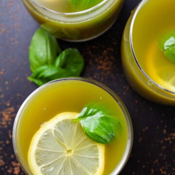 Green Basil lemonade drinks garnished with lemon wedges and fresh basil