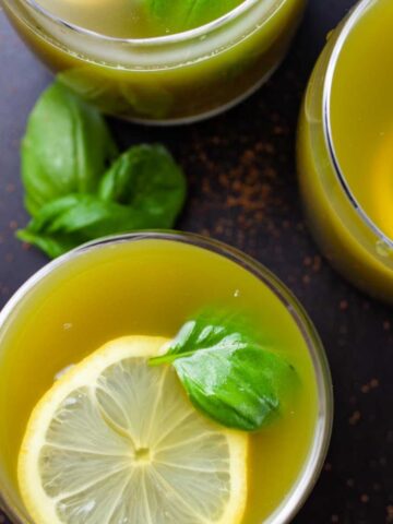 Green Basil lemonade drinks garnished with lemon wedges and fresh basil