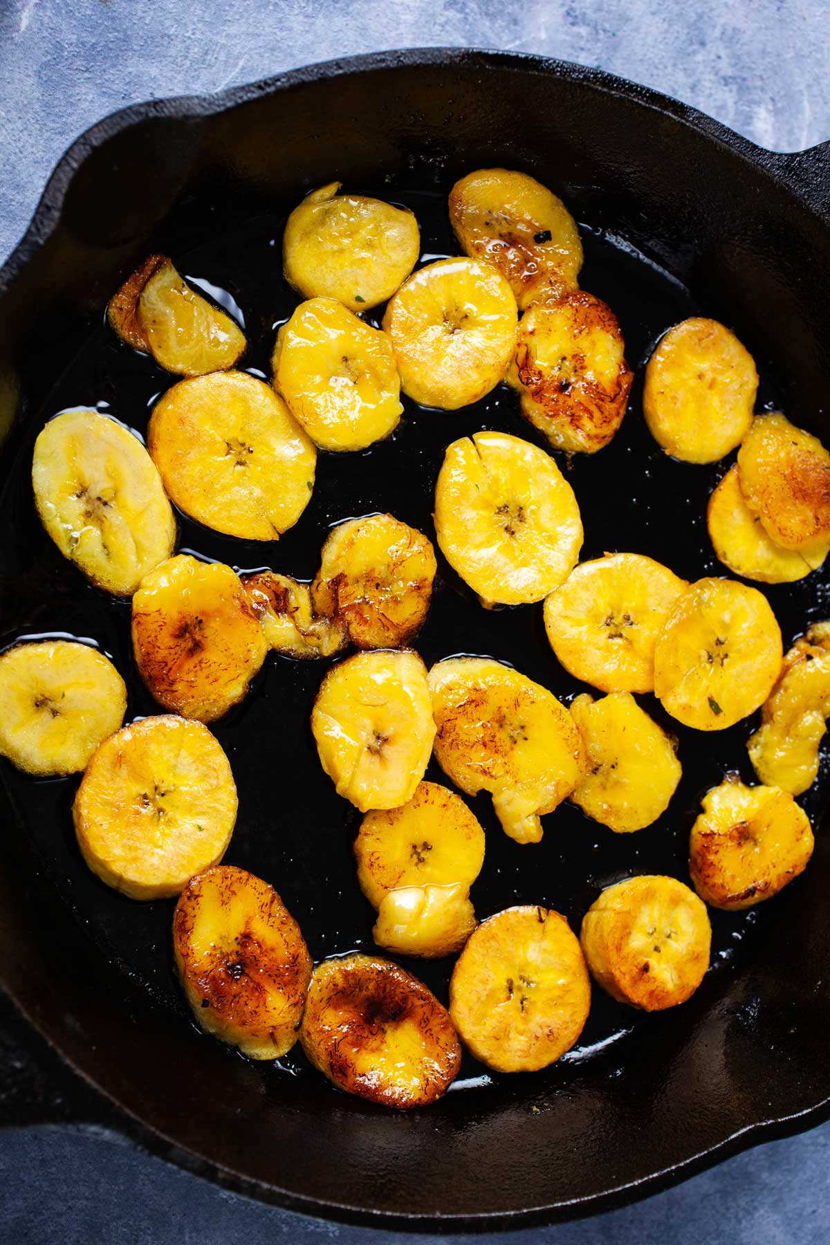 Fried plantains in a cast-iron pan.