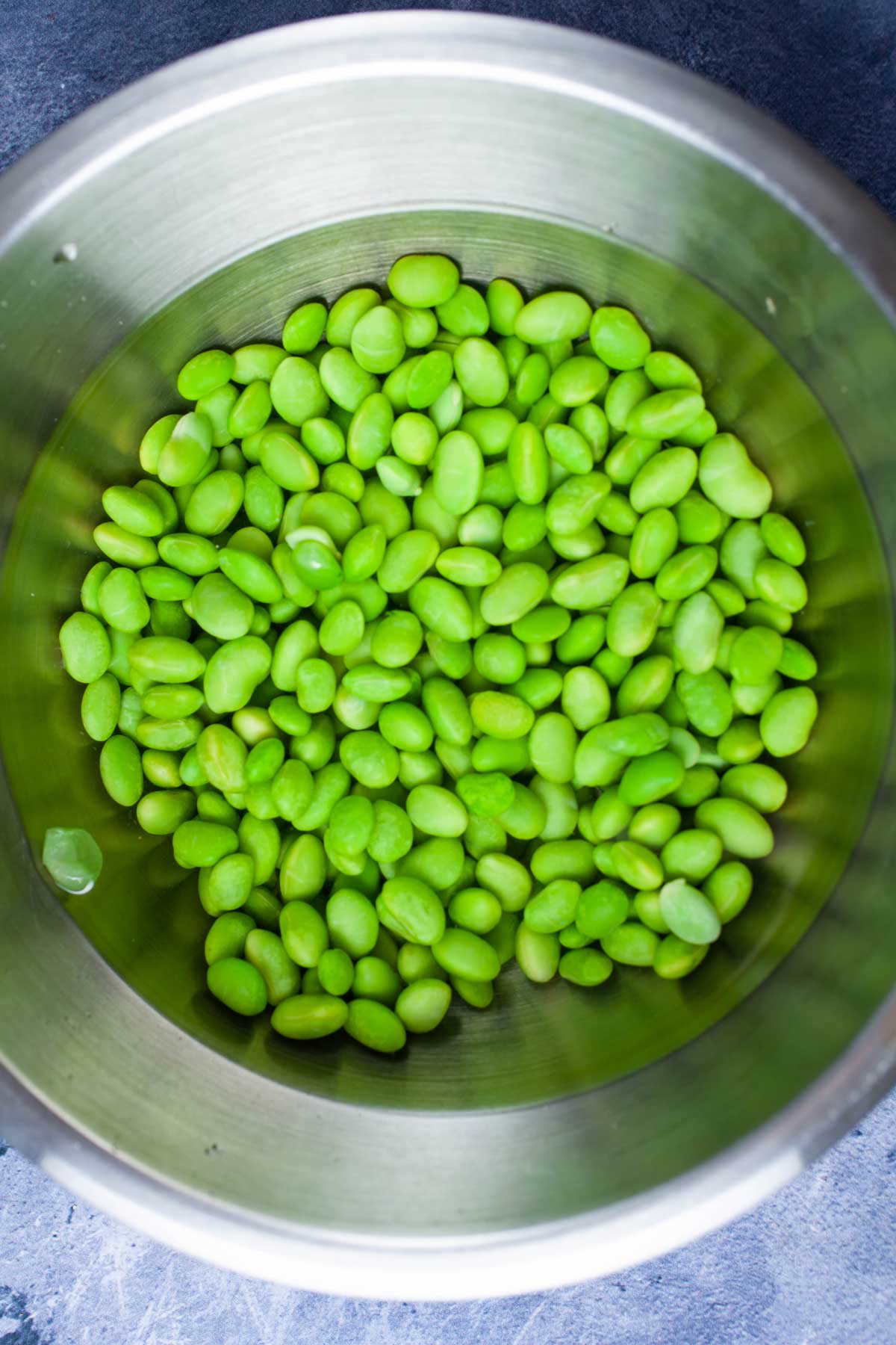 Frozen edamame beans soaked in water.