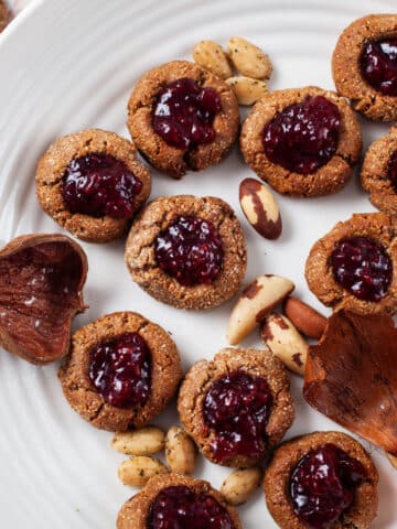 A plate filled with gluten-free almond flour cookies, topped with jam.