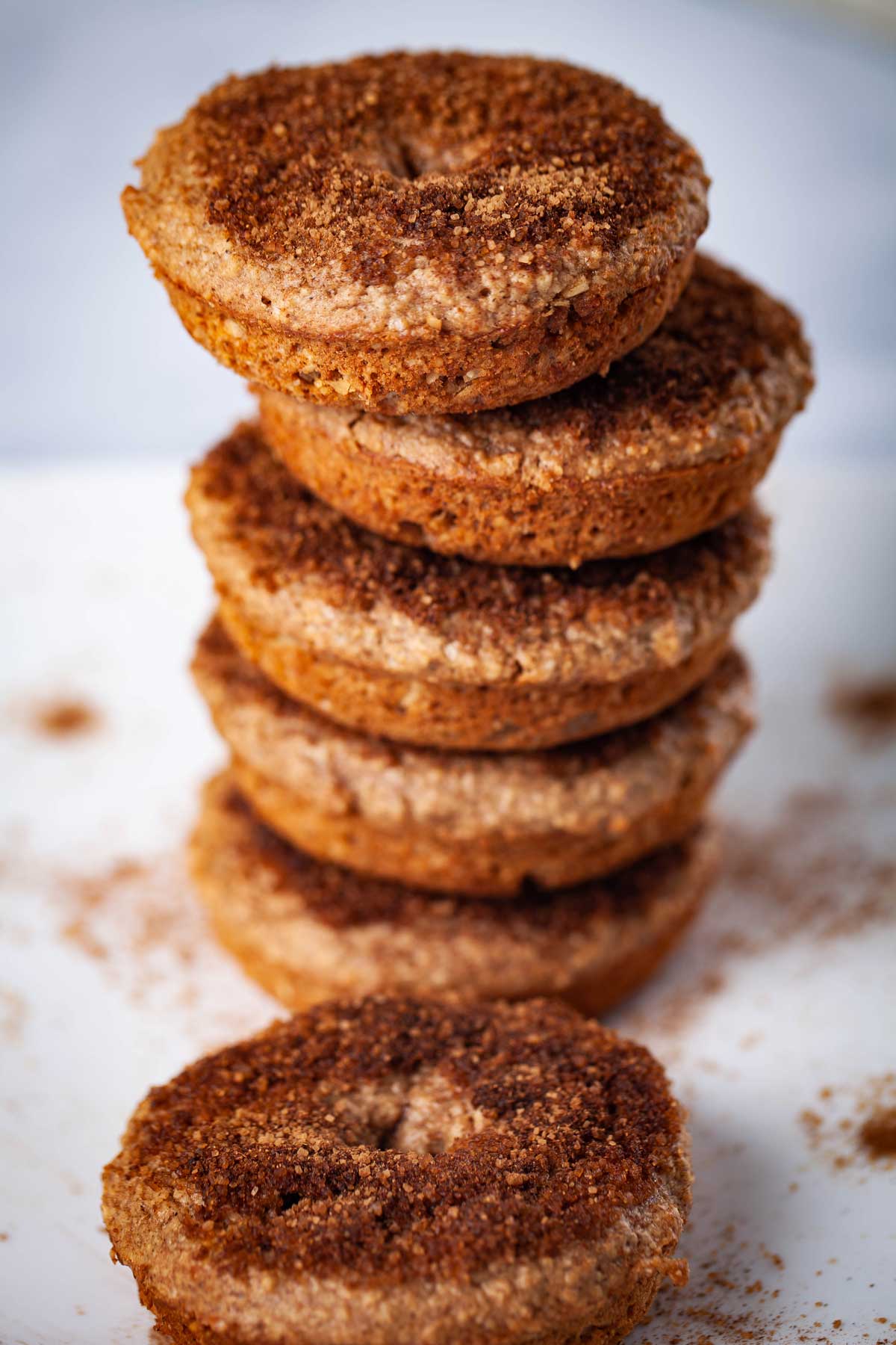 Cinnamon sugary topped doughnuts stacked on top of each other.