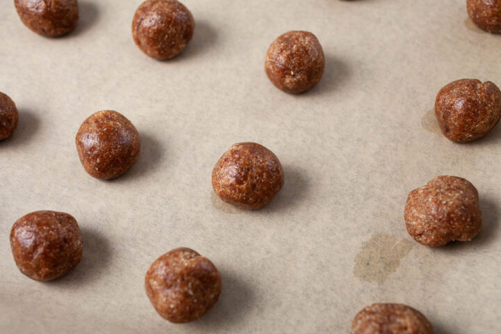 Unbaked almond butter cookies on a prepared baking sheet.