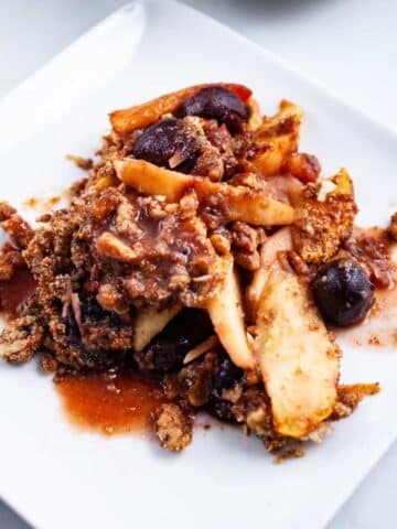 Healthy Paleo apple crumble with cherries served on a plate.