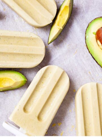 Creamy avocado popsicles on a table.
