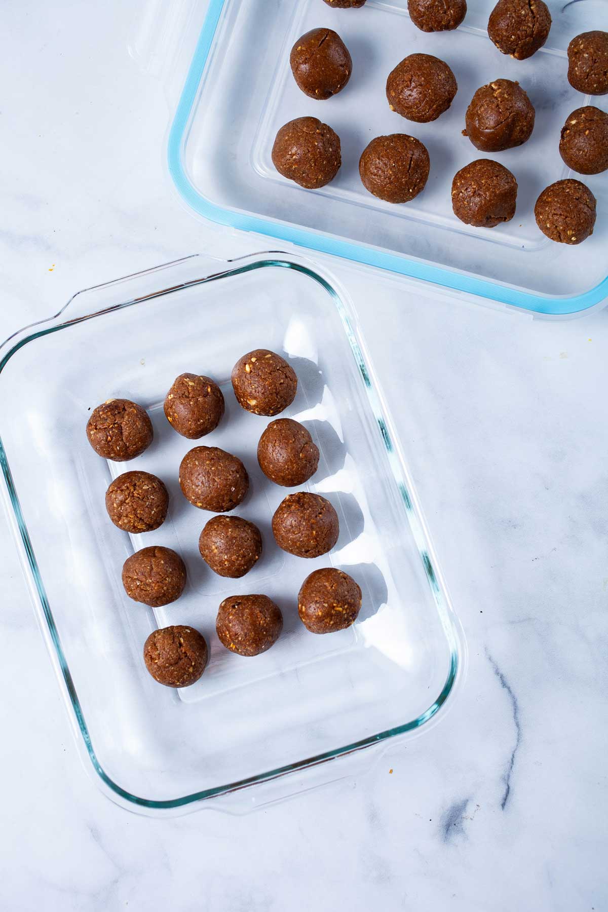 Gluten-free energy balls lined up next to each other in a glass container.