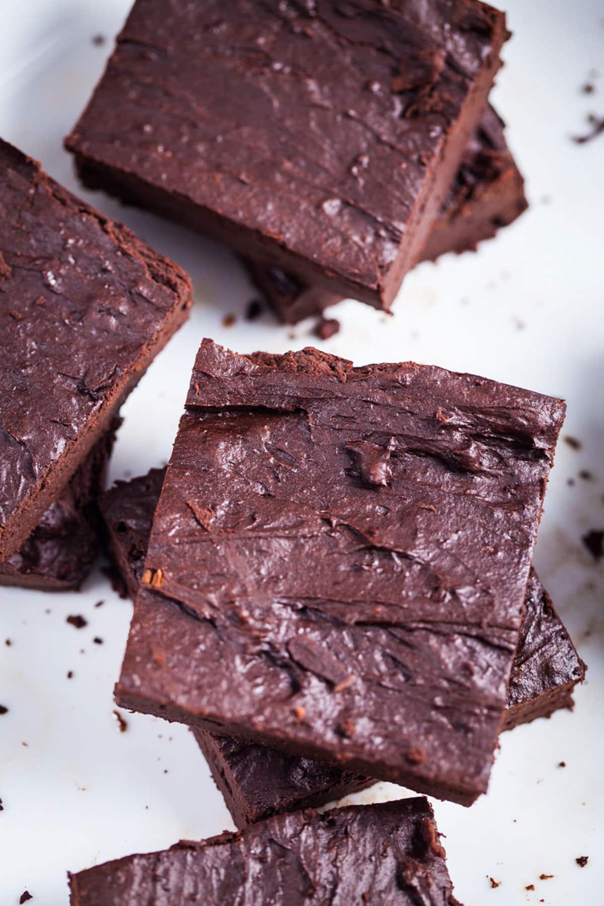 Fudge brwnies with a shiny crust stacked on top of each other.