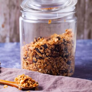 Baked granola stored in a wide-mouth glass jar.