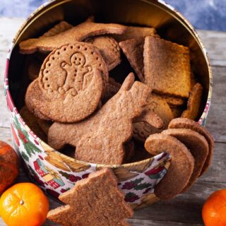 Different shaped brown cookies in a large Holiday cookie box.