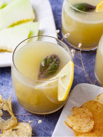 Honeydew lemonade in a glass with basil.