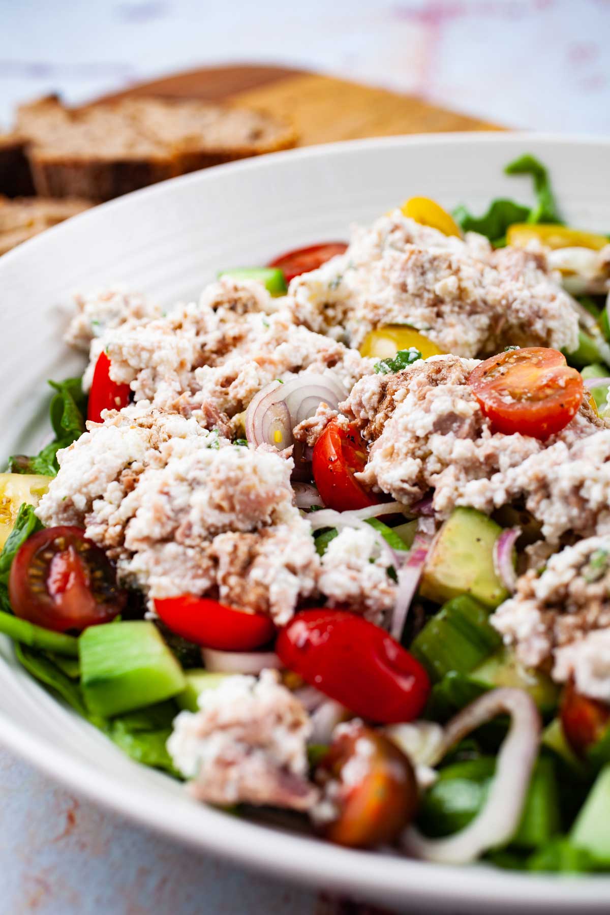 A large serving plate with a tuna cucumber salad with ricotta cheese.