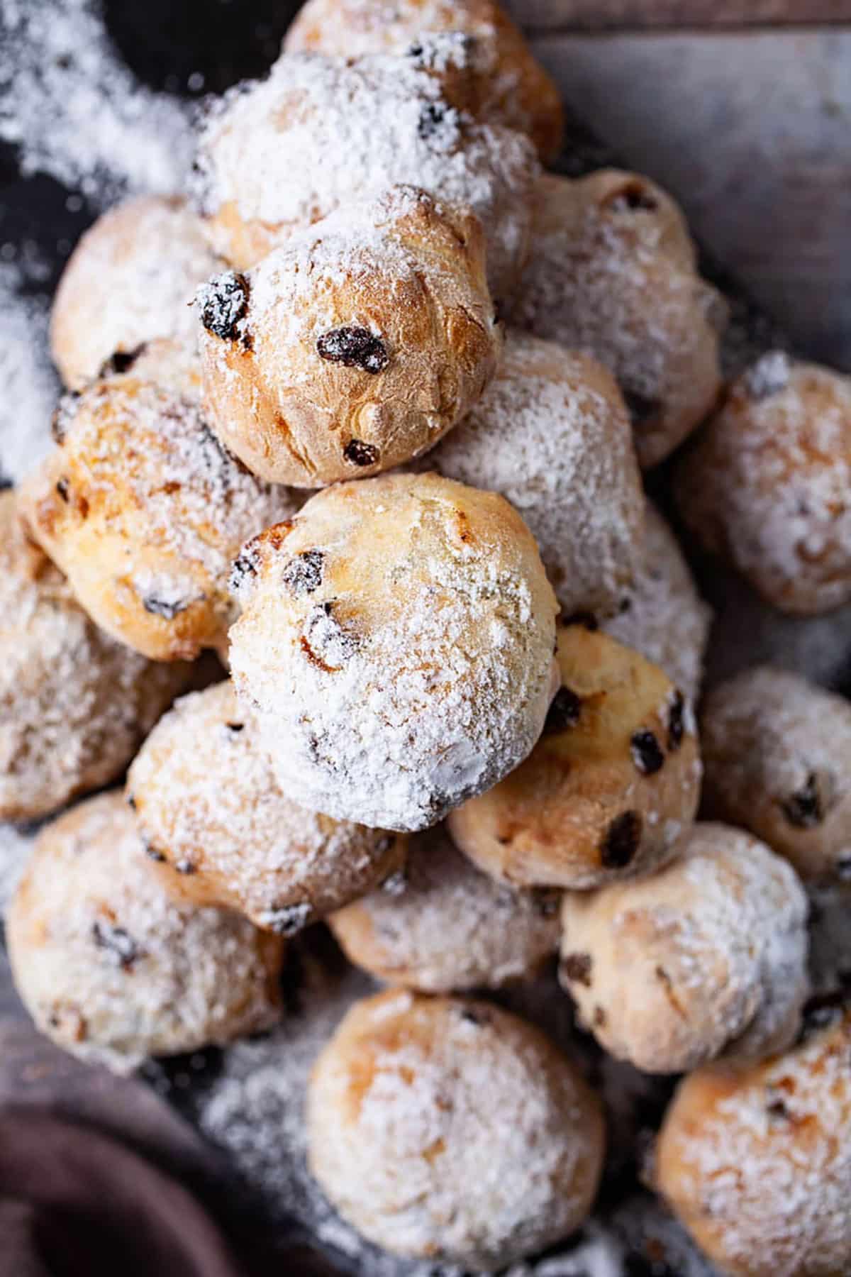 A tower of raisin filled Zeppole doughnuts topped with sugar powder.