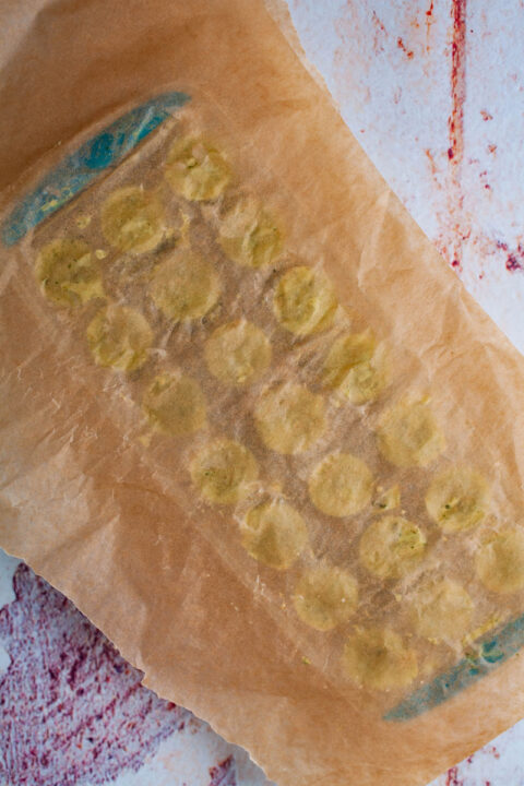 A mini ice cube tray topped with parchment paper.