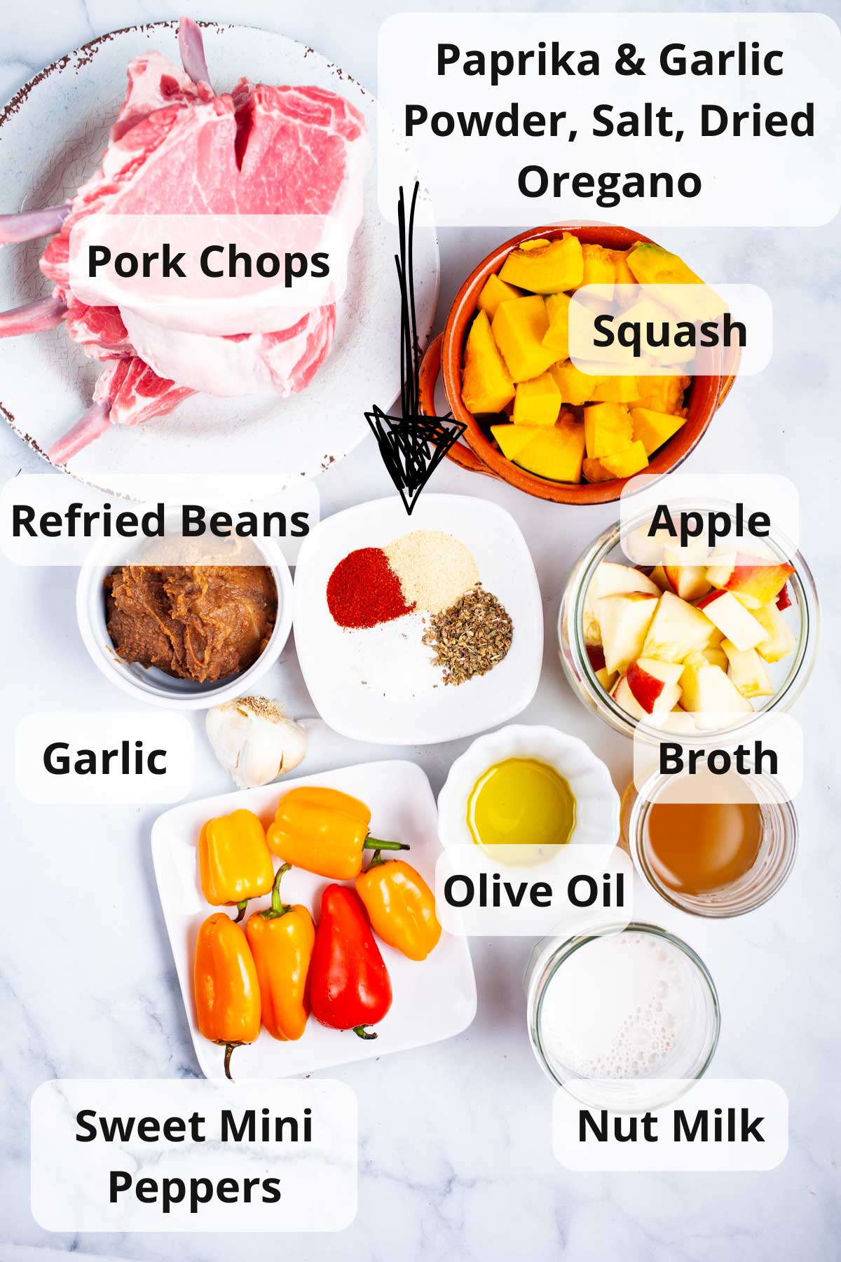 Ingredients laid out on a table to make cast iron pork chops with apples and squash.
