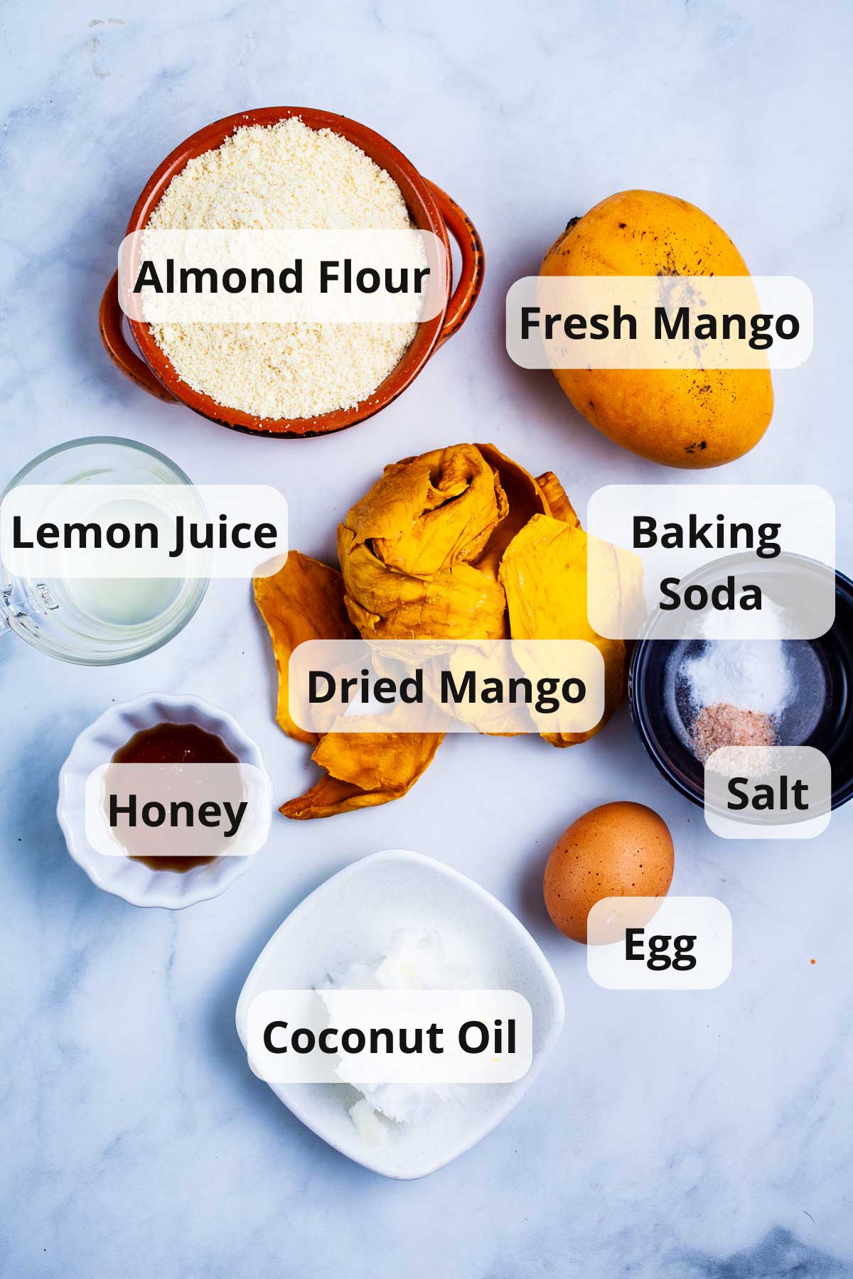 A series of ingredients displayed on a table to make fresh mango cookies.