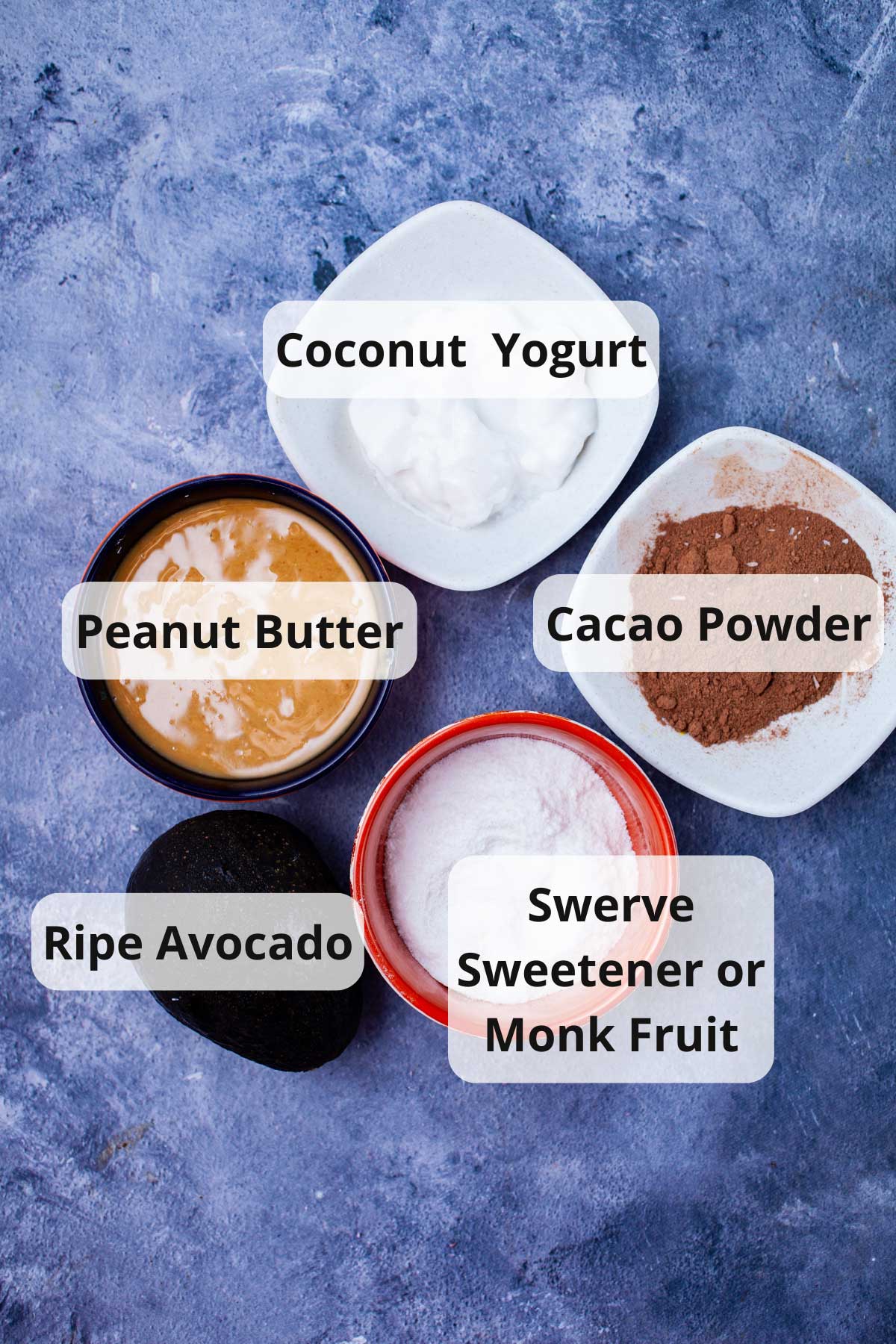 A series of ingredients displayed on a table to make Avocado and peanut butter mousse.