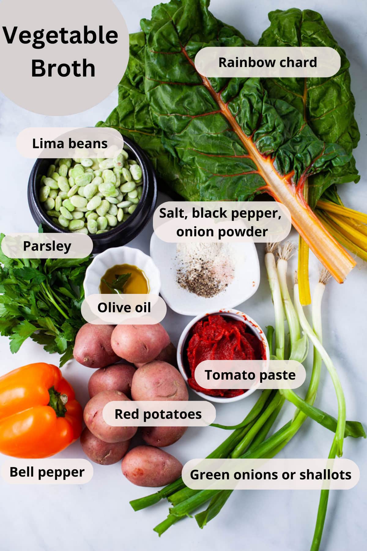 Rainbow chard, lima beans, fresh parsley, olive oil, seasoning, tomato paste, potatoes, bell pepper, and green onions on a table.