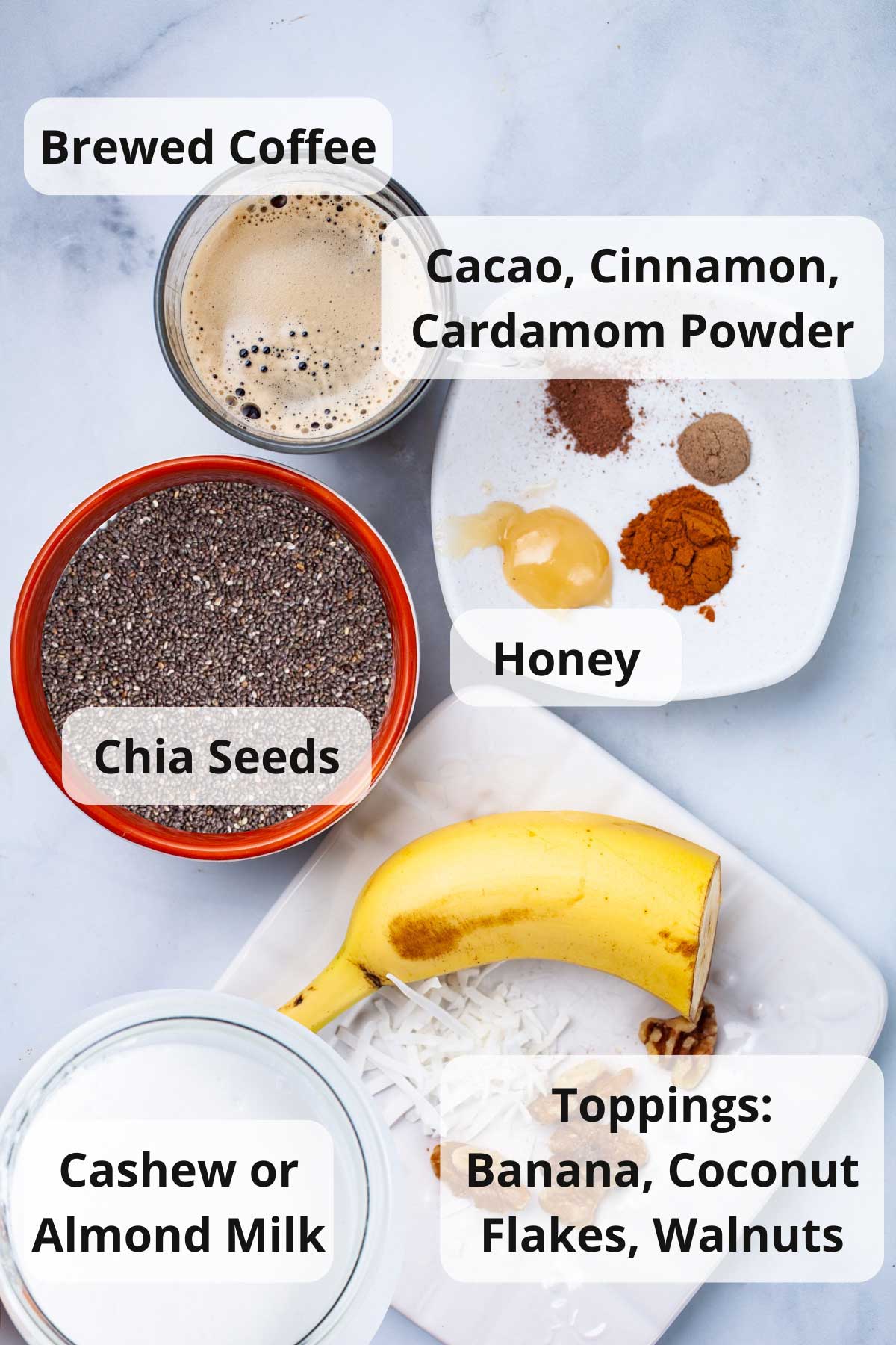 Brewed coffee, cashew milk, cacao, cinnamon, cardamom, honey, chia seeds, nuts, and fruits displayed on a table.