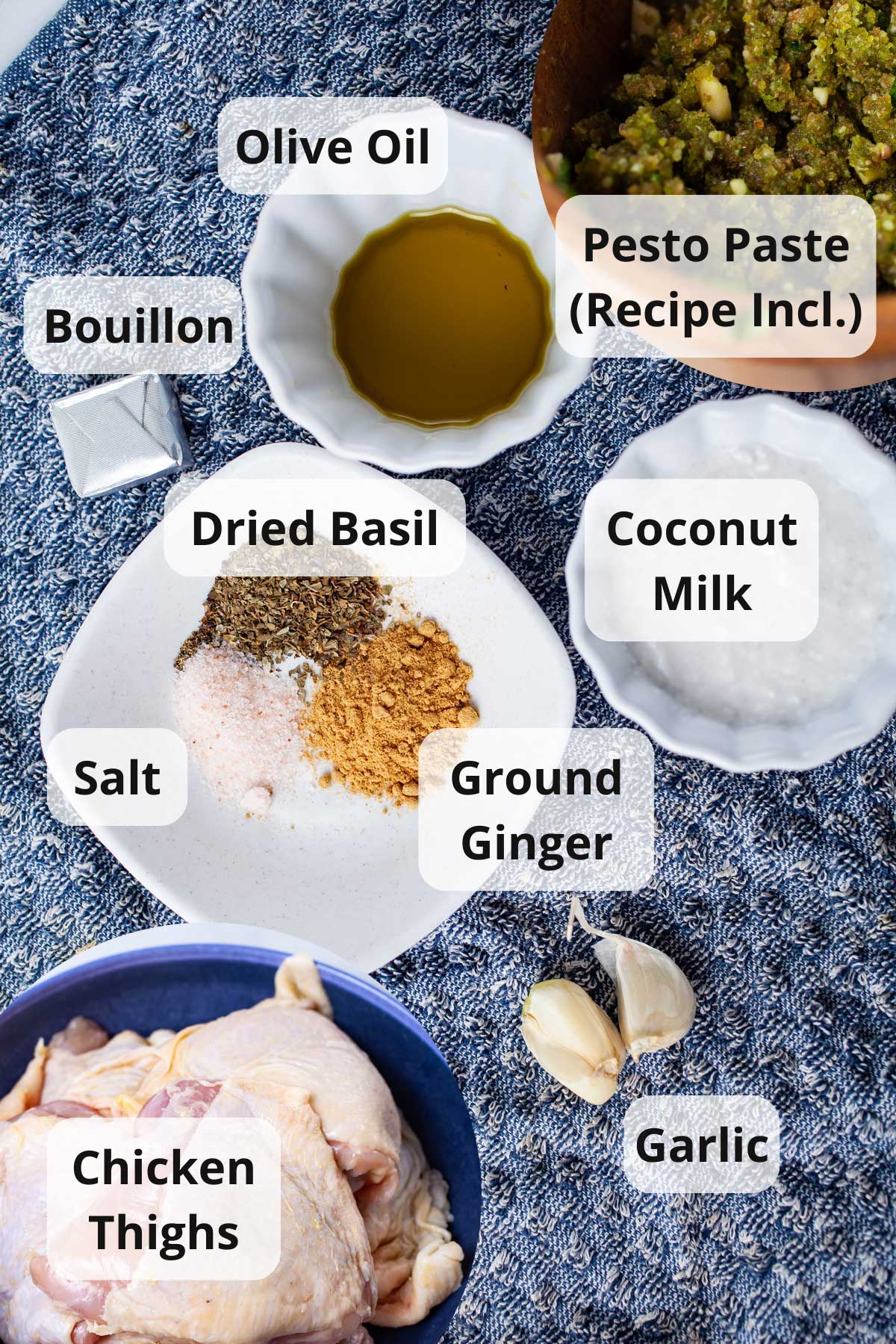 A series of ingredients displayed on a table to make pesto chicken thighs.