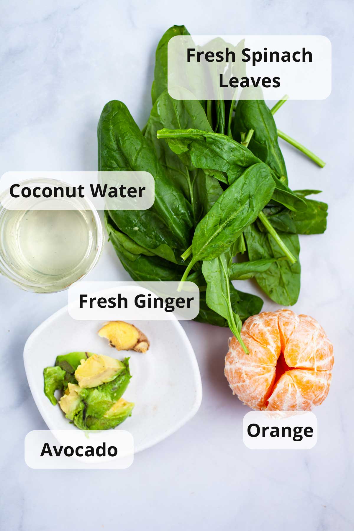 Ingredients on a table to make a spinach orange smoothie.