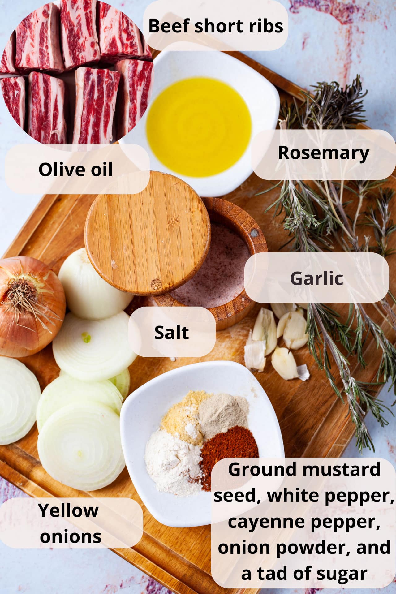 A wooden board containing sliced onions, a bowl of spices, a salt pot, olive oil, garlic, and dried Rosemary leaves.