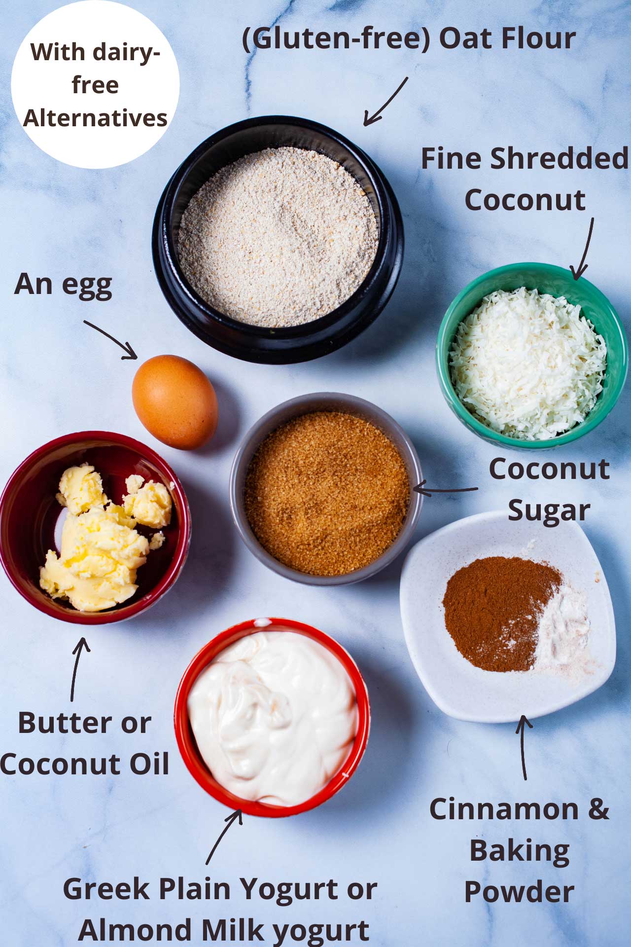 Ingredients to make baked doughnuts: oat flour, fine shredded coconut, coconut sugar, cinnamon and baking powder, plain yogurt or almond yogurt, butter or coconut oil, and an egg.