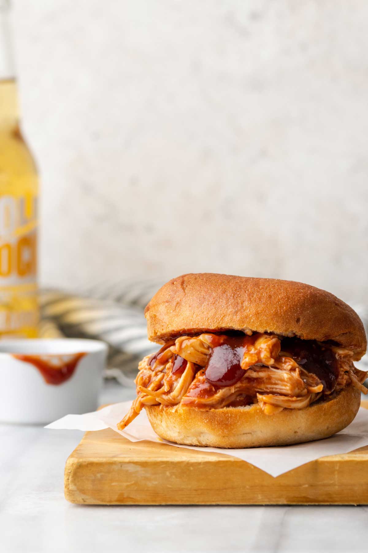 A burger filled with Instant pot bbq chicken and sauce.