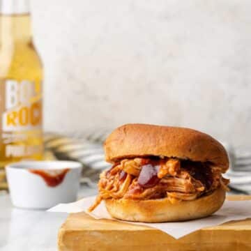 A burger filled with Instant pot bbq chicken and sauce.