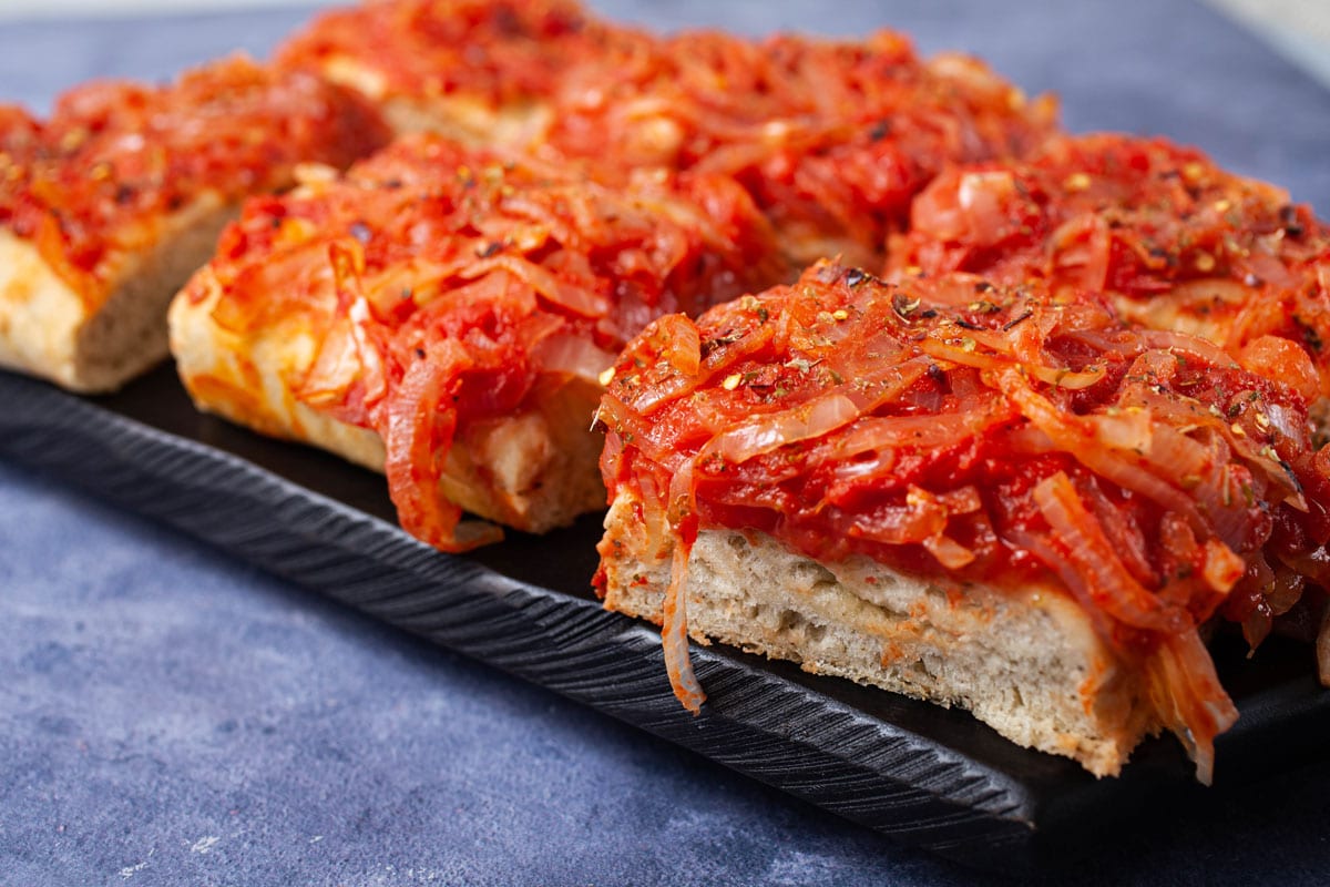Squared pepper and onion pizza with a thick crust.