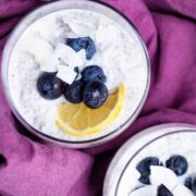 Two cups filled with lemon chia pudding topped with blueberries.